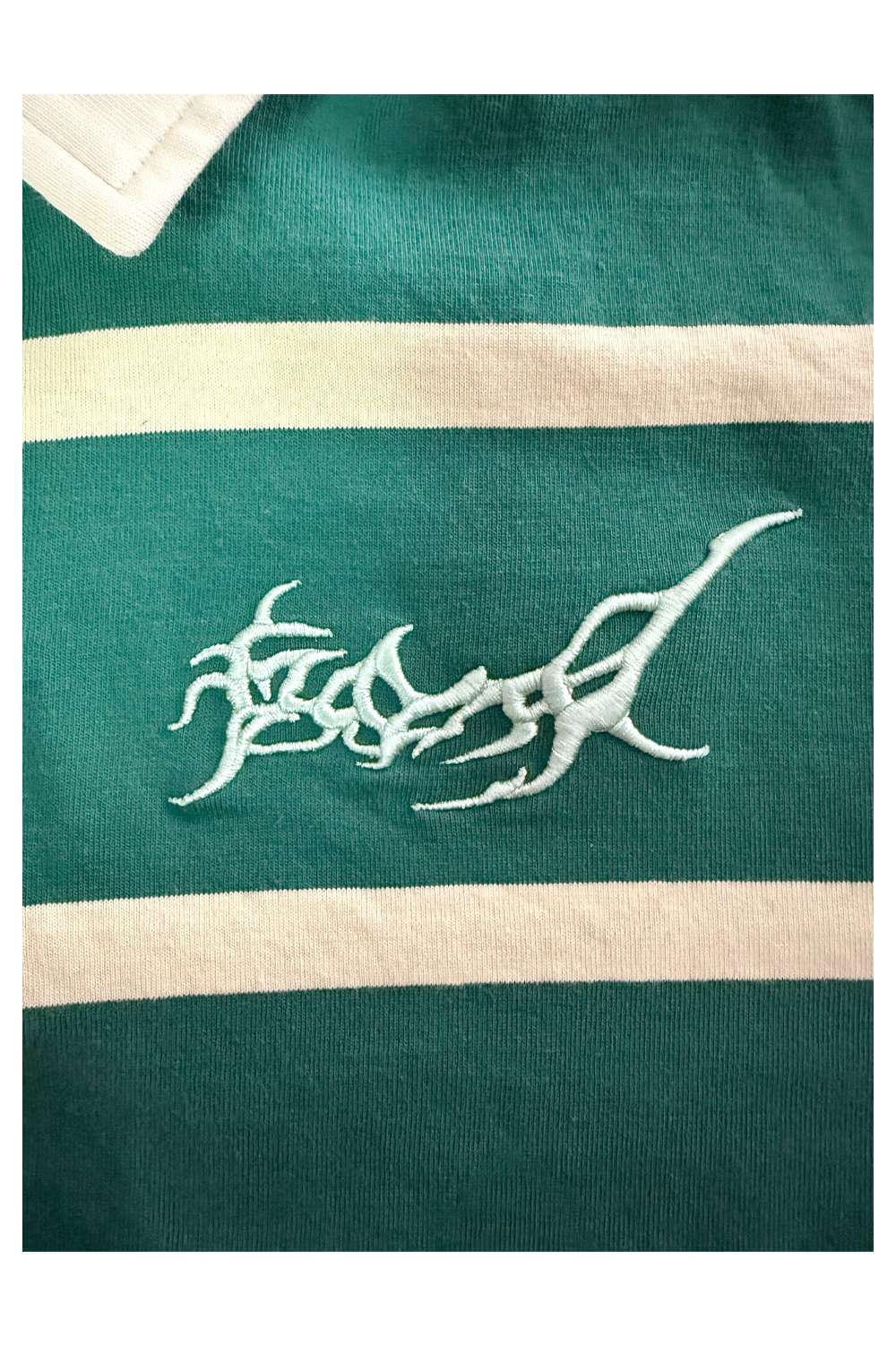 Close-up of the silver organic tribal embroidery on the David William green KBERG jersey, showing the high-quality stitch detail and metallic texture.